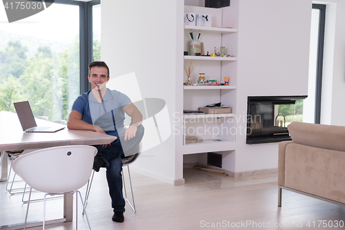 Image of Young man with laptop at home