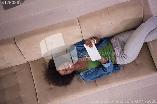 Image of african american woman at home with digital tablet top view