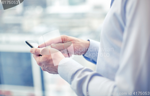 Image of close up of man hands with smartphone at office