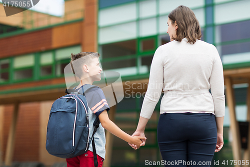 Image of elementary student boy with mother at school yard