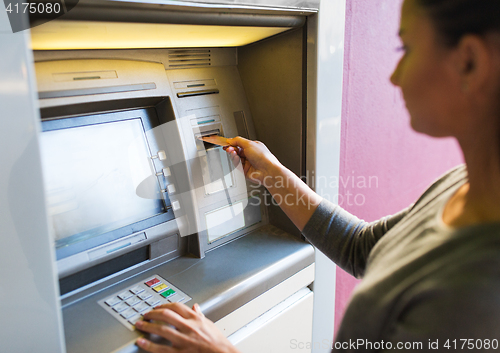 Image of close up of woman inserting card to atm machine