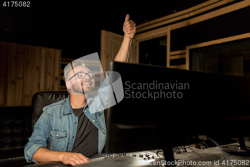 Image of man at mixing console in music recording studio