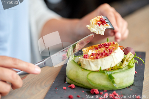 Image of woman eating goat cheese salad at restaurant