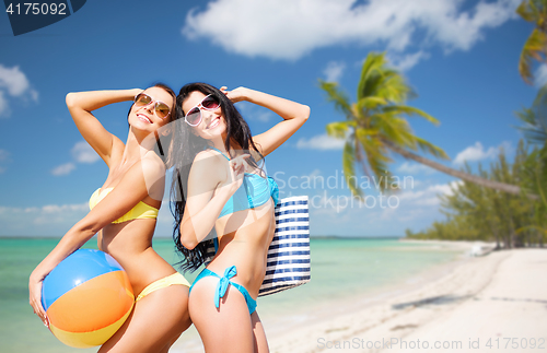 Image of happy young women in bikini posing on summer beach