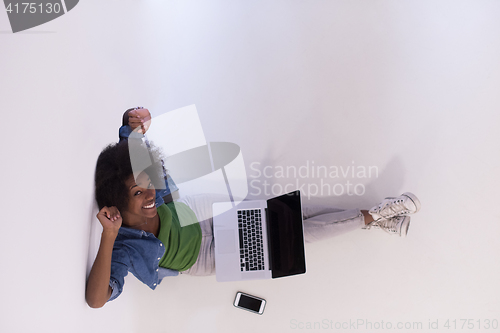 Image of african american woman sitting on floor with laptop top view