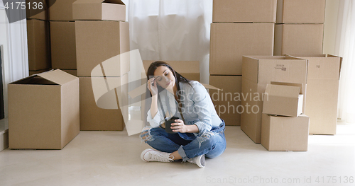 Image of Tired young woman taking a break from moving house