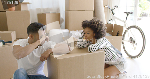 Image of Exhausted couple taking a break from packing