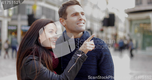 Image of Attractive young woman pointing out something