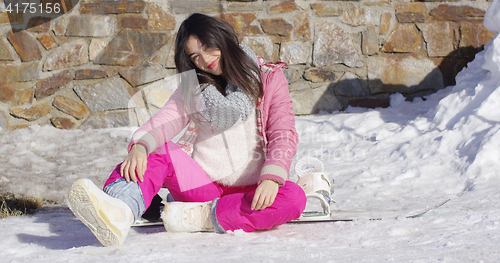 Image of Young asian snowboarder girl relaxing