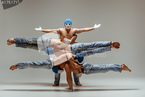 Image of The group of gymnastic acrobatic caucasian men on balance pose