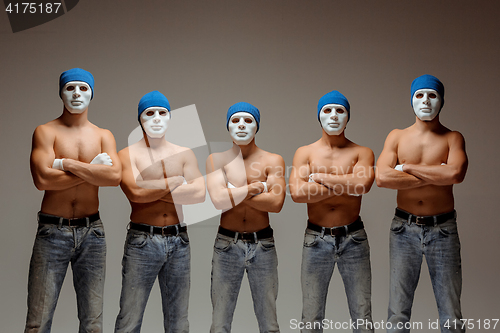 Image of The group of caucasian men in white masks and hats, jeans