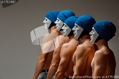 Image of The group of caucasian men in white masks and hats, jeans