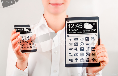 Image of Smartphone and tablet with transparent screen in human hands.