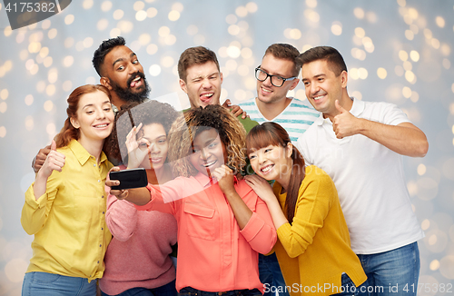 Image of group of people taking selfie by smartphone