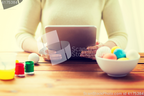 Image of close up of woman with tablet pc and easter eggs