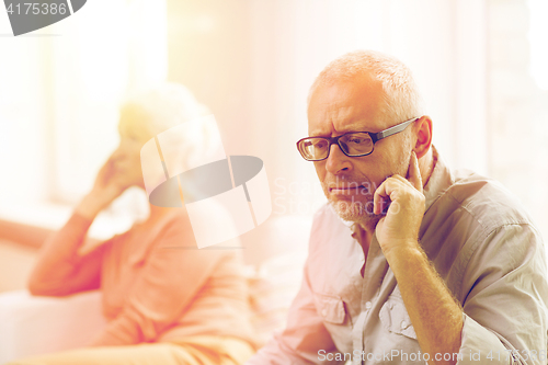 Image of senior couple sitting on sofa at home