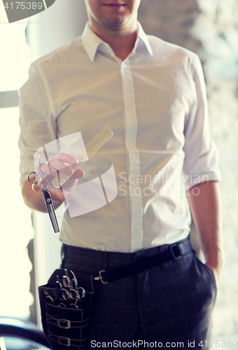 Image of close up of male stylist with scissors at salon