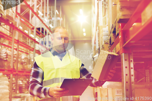 Image of man with clipboard in safety vest at warehouse