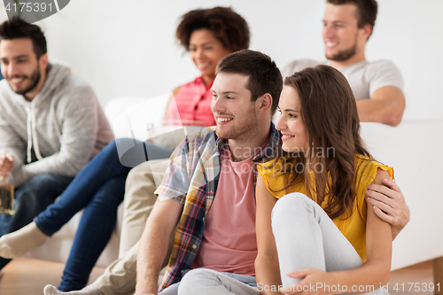 Image of happy couple with friends watching tv at home