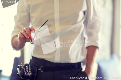 Image of close up of male stylist with scissors at salon