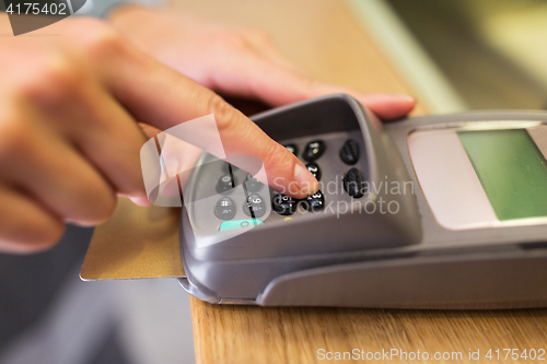 Image of close up of hand entering code to money terminal