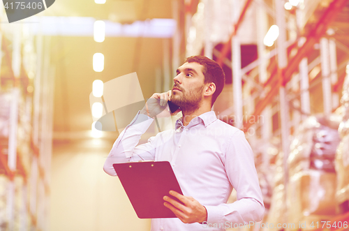 Image of man with clipboard and smartphone at warehouse