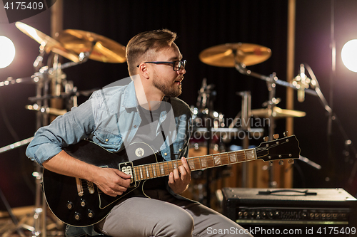 Image of man playing guitar at studio rehearsal