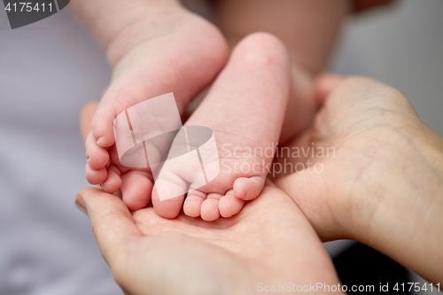 Image of close up of newborn baby feet in mother hands