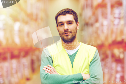 Image of happy man in reflective safety vest at warehouse