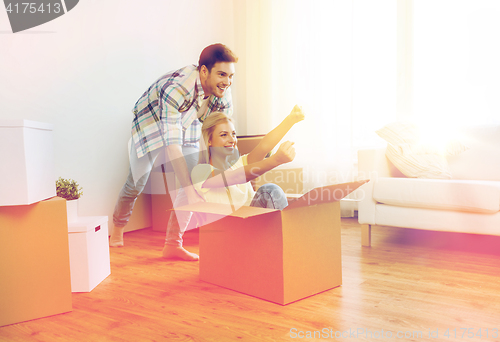 Image of happy couple having fun with boxes at new home