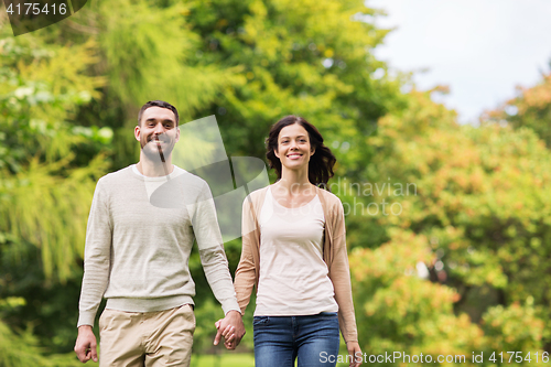 Image of happy couple walking in summer park