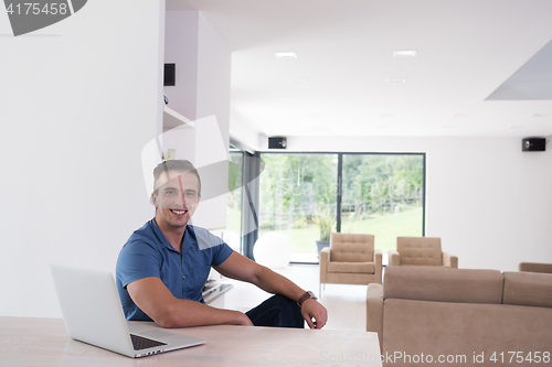 Image of Young man with laptop at home