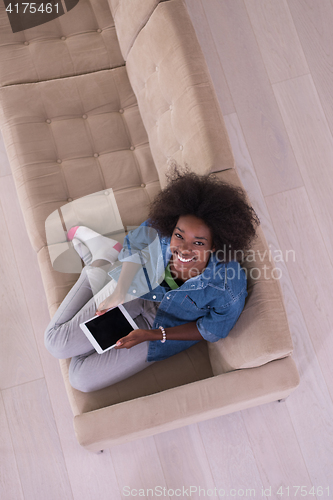 Image of african american woman at home with digital tablet top view