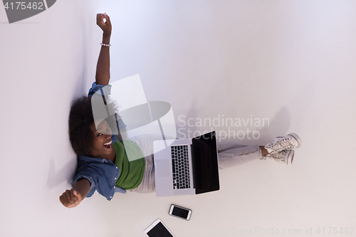 Image of african american woman sitting on floor with laptop top view