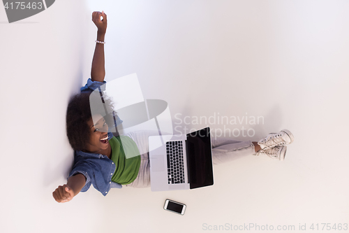 Image of african american woman sitting on floor with laptop top view