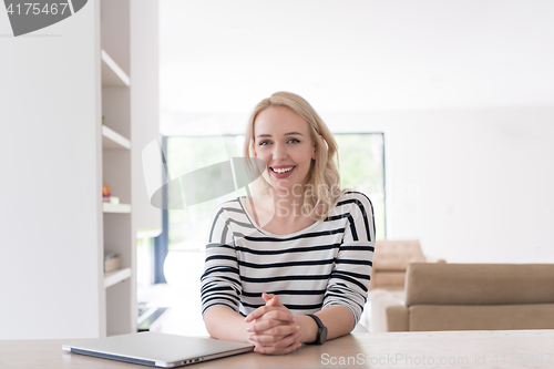 Image of Young woman with laptop at home