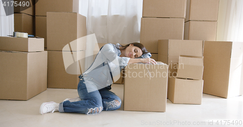 Image of Tired young woman taking a break from packing