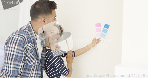 Image of Young couple choosing a paint color