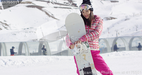 Image of Pretty young asian woman holding snowboard