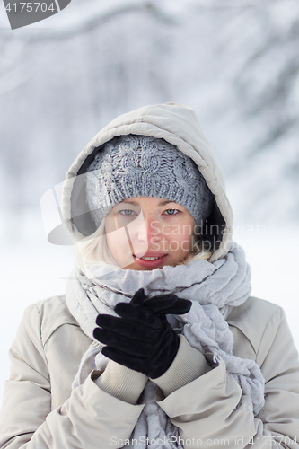 Image of Portrait of lady outdoor in snow in cold winter time.