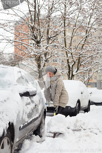 Image of Independent woman shoveling snow in winter.