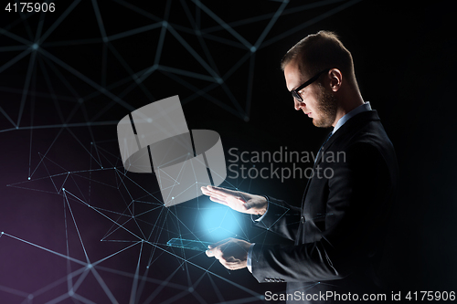 Image of businessman with light above transparent tablet pc