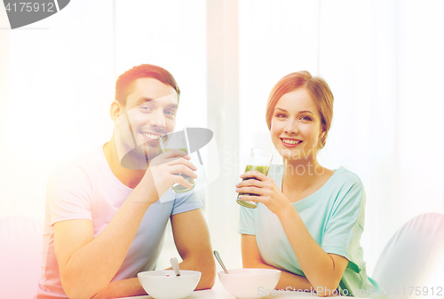 Image of smiling couple having breakfast at home