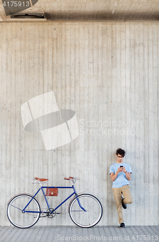 Image of man with smartphone and fixed gear bike on street