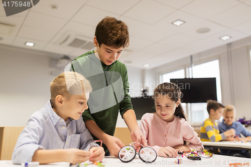 Image of happy children building robots at robotics school