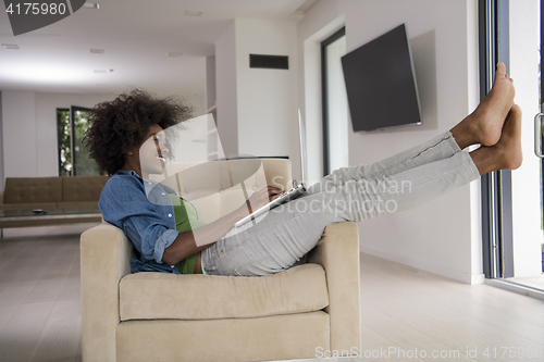 Image of African American women at home in the chair using a laptop