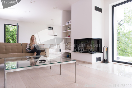 Image of woman sitting on sofa with mobile phone