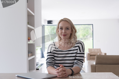 Image of Young woman with laptop at home