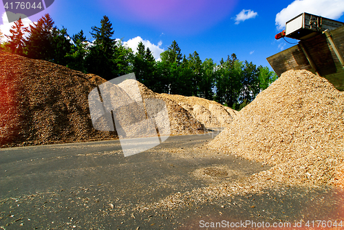 Image of storage of wooden fuel (biomass) against blue sky