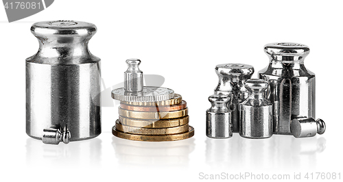 Image of Several old scaling weights and coins